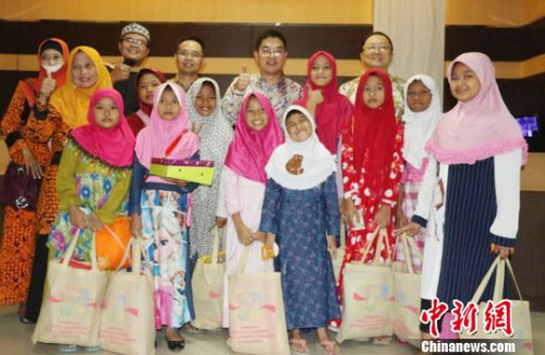 圖為顧景奇向孤兒和貧困兒童發(fā)放禮包?！∏貫榉?攝