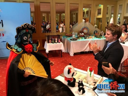 川劇表演藝術(shù)家在奧地利活動(dòng)現(xiàn)場(chǎng)向外賓表演變臉?！∮伤拇ㄍ鈨S辦提供 攝 川劇表演藝術(shù)家在奧地利活動(dòng)現(xiàn)場(chǎng)向外賓表演變臉?！∮伤拇ㄍ鈨S辦提供 攝