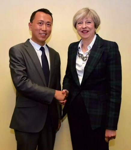 參加2017年英國大選的華裔候選人何易與英國首相特雷莎·梅合影。(受訪者供圖)