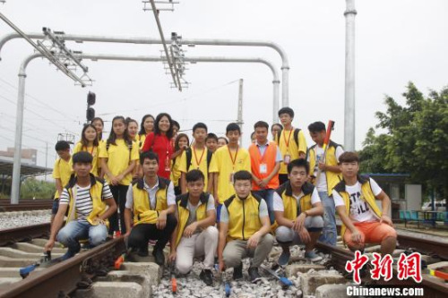 華裔青少年在軌道上合影?！≈炝?攝