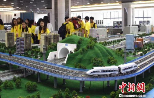 華裔青少年在觀看高鐵運(yùn)行沙盤(pán)?！≈炝?攝
