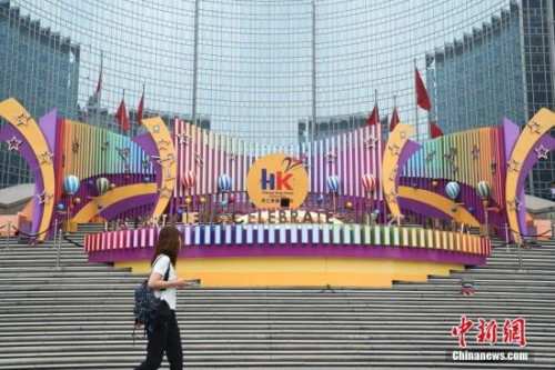 6月28日，市民從位于北京王府井東方廣場的一處慶祝香港回歸20周年的裝飾前走過。7月1日，香港特別行政區(qū)政府將迎來成立20周年紀(jì)念。<a target='_blank' >中新社</a>記者 侯宇 攝