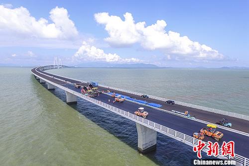 圖為6月8日，工人們?cè)诟壑榘拇髽蛏线M(jìn)行橋面鋪裝。 <a target='_blank' >中新社</a>記者 陳驥旻 攝