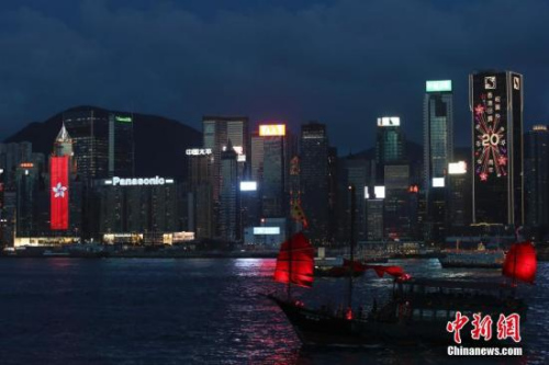 香港回歸祖國(guó)二十周年慶典臨近，香港慶回歸氣氛漸濃，6月27日晚，在維多利亞港灣兩側(cè)霓虹閃爍，大廈上的電子屏“升起”巨幅五星紅旗和紫荊花區(qū)旗，交替展現(xiàn)，并有“熱烈慶祝香港回歸祖國(guó)20周年”、“祝賀香港回歸20周年”字樣。 <a target='_blank' >中新社</a>記者 盛佳鵬 攝