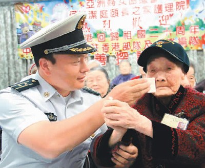 遼寧艦編隊與駐香港部隊官兵7月10日下午前往香港亞洲婦女協(xié)進會頤養(yǎng)之家護理院看望并慰問老人。已經(jīng)在護理院住了18年的110歲老人謝月瓊，興奮地豎起大拇指，留下了激動的淚水。圖為遼寧艦編隊官兵細心地為老人擦去淚水。 　　辜雨晴攝