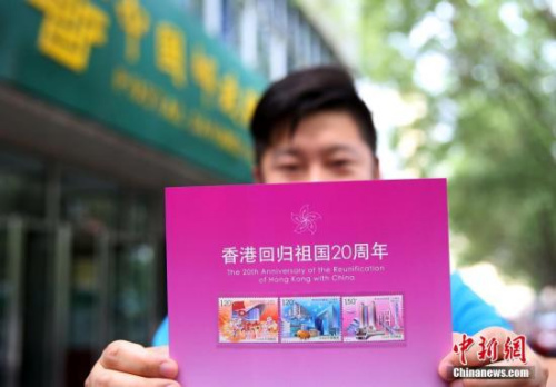 資料圖：2017年7月1日，北京集郵愛(ài)好者展示《香港回歸祖國(guó)二十周年》紀(jì)念郵票。當(dāng)日，為慶祝香港回歸祖國(guó)二十周年，中國(guó)郵政發(fā)行《香港回歸祖國(guó)二十周年》紀(jì)念郵票。 <a target='_blank' >中新社</a>記者 卞正鋒 攝