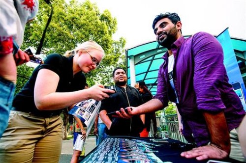 圖為HanNation的團(tuán)隊成員塞舍爾（右）在校園里向留學(xué)生推介他們的APP。