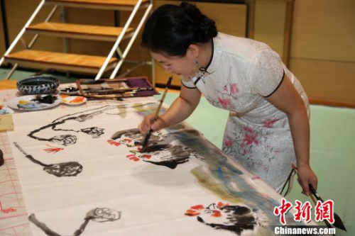 圖為“2017年中華文化大樂園--日本橫濱夏令營(yíng)”優(yōu)秀教師團(tuán)的陳聰老師在開營(yíng)式上現(xiàn)場(chǎng)創(chuàng)作國(guó)畫作品?！∫ǜ?攝