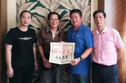 容榮仲先生(左二)向江門市博物館館長黃志強(qiáng)捐贈史料，右一為容樹榮先生(容榮仲在江門生活的侄兒)，左一為江門市博物館副館長林軍