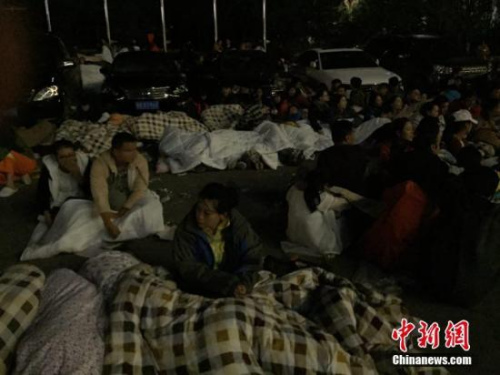 圖為九寨溝景區(qū)內(nèi)，許多游客不敢繼續(xù)待在酒店內(nèi)，裹著厚衣服和毛毯來到街上席地而睡。 徐廣 攝