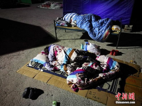 8月10日凌晨2時許，記者抵達四川阿壩州九寨溝地震災區(qū)，隨即走進永樂鎮(zhèn)清平三村村委會、梨花廣場避難場所探訪，眾多民眾為躲避余震，一家人擠在一起睡在露天廣場，深夜氣溫僅有13度。<a target='_blank'  >中新網(wǎng)</a>記者 陳文 攝