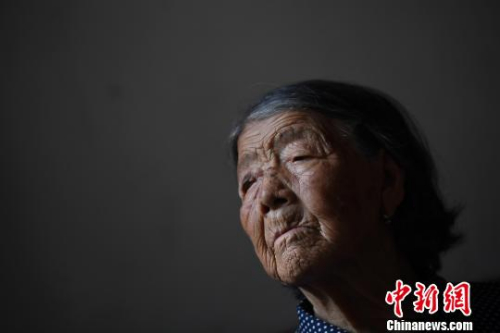 90歲的郝月連靜坐在屋里，看到陌生人進(jìn)屋，她遲疑了片刻說，“你們又來看我啦！”多年來，不少愛心人士專程到此看望老人，老年癡呆的郝月連，已經(jīng)記不得他們的模樣。　韋亮 攝
