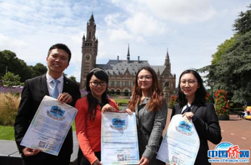 (圖為旅荷國(guó)際法學(xué)學(xué)者海牙和平宮前展示海報(bào)，宣傳他們針對(duì)南海仲裁案撰寫的公開信，尋求國(guó)際法正義，左二穿紅衣者是作者彭芩萱。作者供圖)