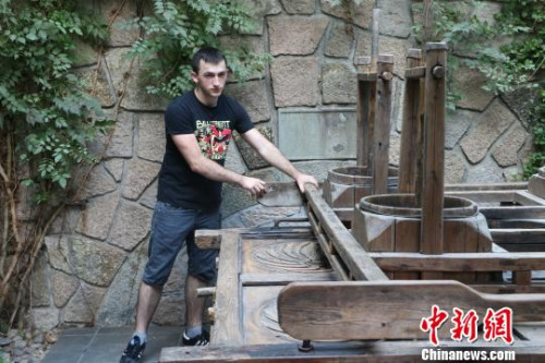 圖為：德國漢諾威孔子學(xué)院學(xué)生體驗四桶茶葉揉捻機(jī)?！⊥鯙t婧 攝