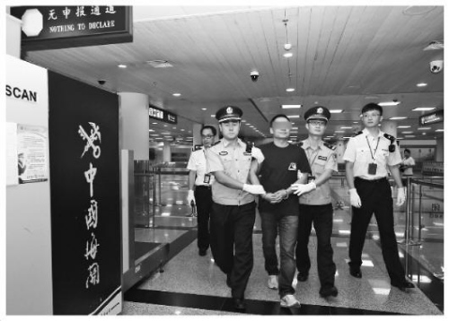 圖為拱北海關(guān)緝私警察將紀(jì)某押出機(jī)場海關(guān)通道。張建林 攝