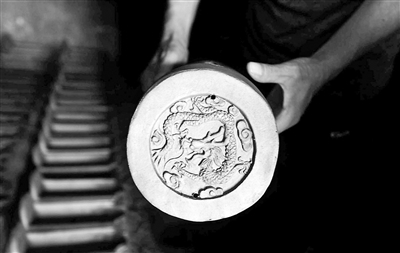 古都國(guó)華琉璃廠經(jīng)理孫宏利展示琉璃半成品上刻有的圖案。停產(chǎn)后，廠子只能將部分半成品運(yùn)到山西進(jìn)行二次加工