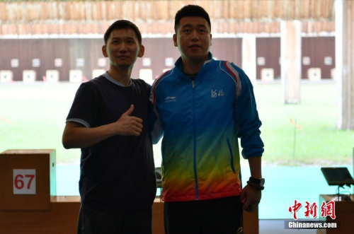  8月28日，天津團泊體育中心射擊館，美籍華人選手石晶參加第十三屆全國運動會男子50米手槍預賽，位列第18名。圖為賽后，石晶（左一）和龐偉合影留念。 <a target='_blank' >中新社</a>記者 翟羽佳 攝
