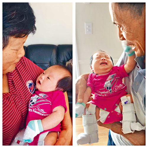 小孫女轉(zhuǎn)眼滿月，兩老抱在懷里樂開了懷。（美國《星島日?qǐng)?bào)》）