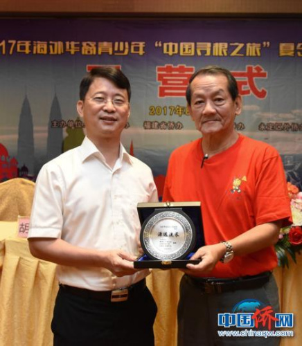 圖為王小慶代表永定區(qū)委、區(qū)政府接受羅良斌贈送的紀(jì)念品?！⒂懒?攝