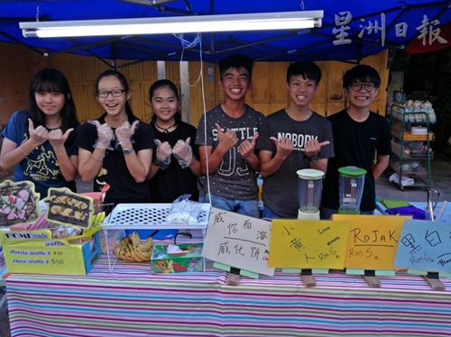 羅俊偉(右二)和同學們利用學校假期擺攤做生意，部份所賺的錢將捐給慈善團體，愛心滿滿。(圖：星洲日報) 