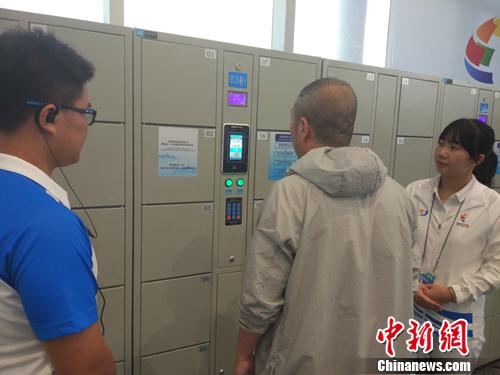 志愿者幫助記者使用電子儲(chǔ)物柜。<a target='_blank'  >中新網(wǎng)</a>記者 李金磊 攝