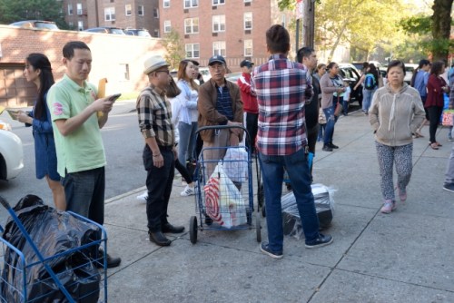 法拉盛家長(zhǎng)推著裝滿文具的菜籃車，等著放入校園置物柜。（美國(guó)《世界日?qǐng)?bào)》/朱澤人 攝）