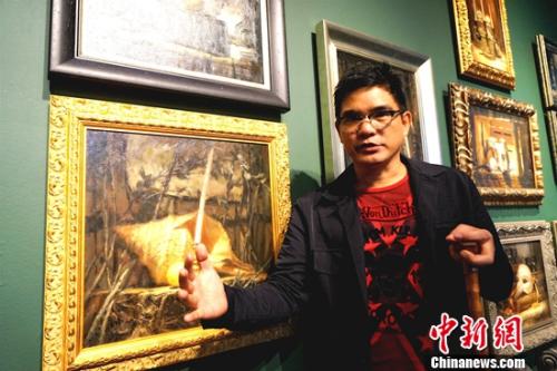 畫(huà)展的主人、菲律賓畫(huà)家阿瑞奧拉(DANILO ARRIOLA)每天坐在輪椅上迎接參觀者。 關(guān)向東 攝