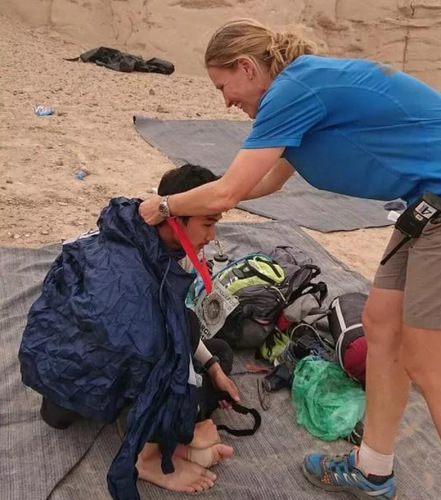 賽事總監(jiān)細(xì)心為體力不支的宋智亮(左)戴上獎(jiǎng)牌，讓遠(yuǎn)在異鄉(xiāng)的他倍感溫馨。(馬來(lái)西亞《星洲日?qǐng)?bào)》)