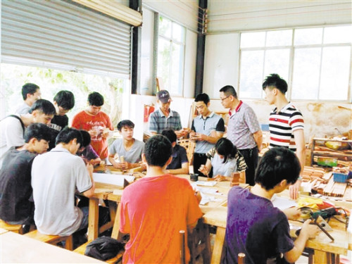 李炳祺在學(xué)校給同學(xué)們上古典家具制作實踐課。