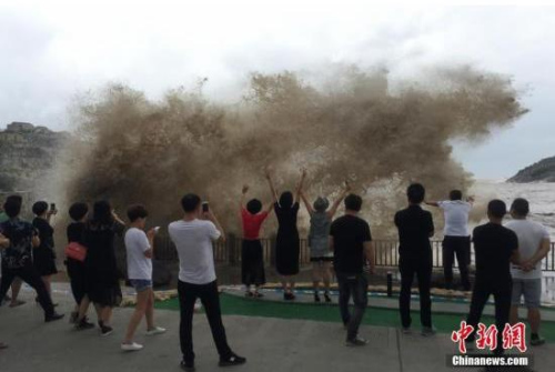 9月14日，游客們?cè)跍貛X三岙觀景平臺(tái)觀浪拍照。當(dāng)天，第18號(hào)超強(qiáng)臺(tái)風(fēng)“泰利”靠近，浙江臺(tái)州溫嶺市石塘鎮(zhèn)金沙灘巨浪滔天，游客們?cè)谌^景平臺(tái)觀浪和拍照片。<a target='_blank' >中新社</a>記者 張琦 攝