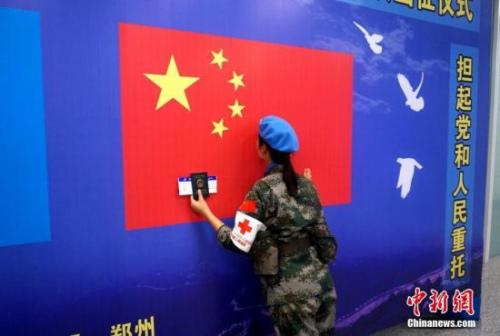 一名維和女兵出征前親吻五星紅旗。 李志全 攝