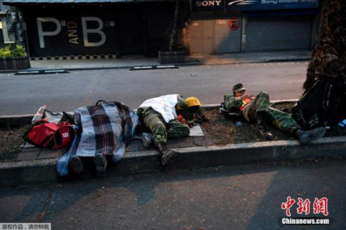 圖為精疲力盡的救援士兵席地而睡。