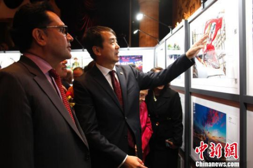 中國駐多倫多總領(lǐng)事何煒與參加慶祝中華人民共和國成立68周年招待會(huì)的嘉賓們共同觀看“中國故事2017”圖片展。　余瑞冬　攝