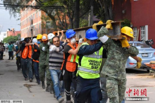 救援人員從震后廢墟中救出了50多人，墨西哥總統(tǒng)培尼亞在全國(guó)講話中稱，眼下的當(dāng)務(wù)之急是救人，堅(jiān)信仍然可能從廢墟中救出更多生還者。圖為救援隊(duì)員合力抬一根鐵梁。