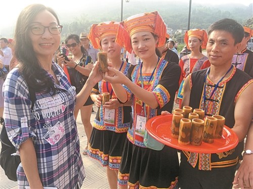 在夏宜瑤族鄉(xiāng)，游客們剛進寨門就嘗到香醇的米酒。 本報記者 梁乾勝/攝