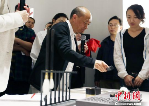 9月29日下午，“盧志榮‘合一’宏觀與微觀世界的緘默”展覽在北京達美藝術中心開幕。此次展覽亦是達美藝術中心的首展，將持續(xù)向公眾開放至11月29日。圖為盧志榮在展覽現(xiàn)場向媒體展示他的作品?！＄娦?攝