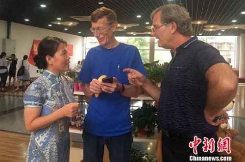 馮翠玲(左一)與外教在溝通工作?！＄娦?攝