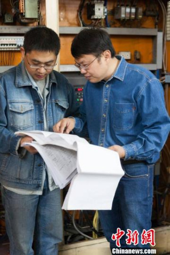 鄧建軍傳授徒弟技術(shù)要領(lǐng)。江蘇常州黑牡丹(集團(tuán))股份有限公司供圖。