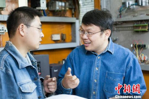 鄧建軍傳授徒弟技術(shù)要領(lǐng)。 江蘇常州黑牡丹(集團(tuán))股份有限公司供圖。