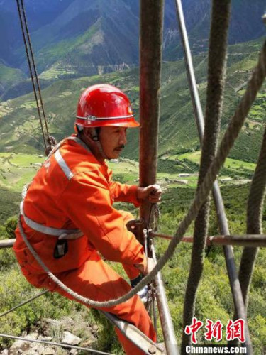 向巴扎西在鉆塔上作業(yè)?！≈芪脑?攝