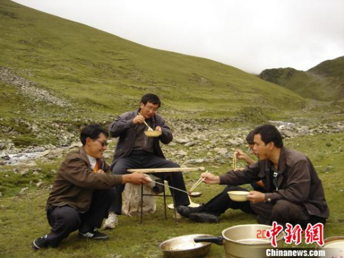 第六地質(zhì)大隊隊員們在曠野外就餐?！≈芪脑?攝