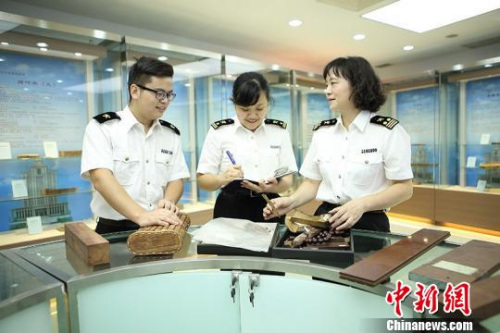 甘露向年輕關(guān)員傳授商品知識 關(guān)悅 攝