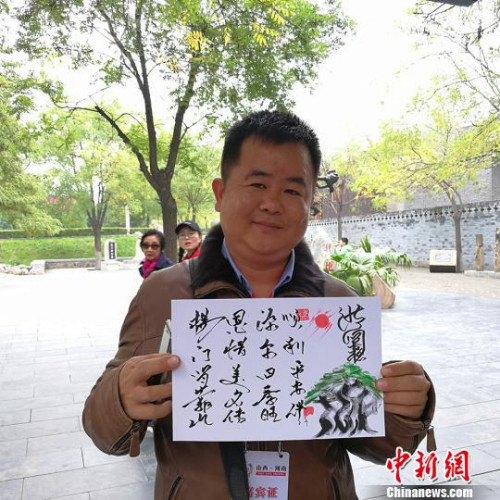 緬甸大其力大華學(xué)校負責(zé)人楊恩源在洪洞大槐樹景區(qū)向記者展示自己姓氏的文創(chuàng)產(chǎn)品?！罱苡?攝