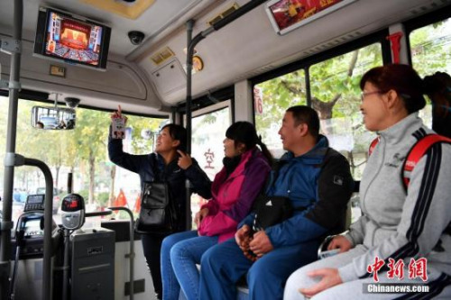 資料圖：10月18日，中國(guó)共產(chǎn)黨第十九次全國(guó)代表大會(huì)開幕，在河北石家莊116路公交車上，幾位市民正在觀看大會(huì)電視直播。<a target='_blank' >中新社</a>記者 翟羽佳 攝