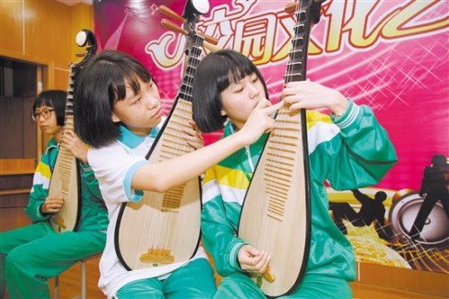 李樹芬紀(jì)念中學(xué)民樂班的學(xué)生在交流彈奏技藝。