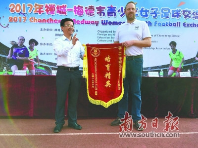 英國(guó)梅德韋市安卡利亞球會(huì)會(huì)長(zhǎng)李·威利斯金向禪城區(qū)文化體育局代表贈(zèng)予錦旗。梁志毅 攝