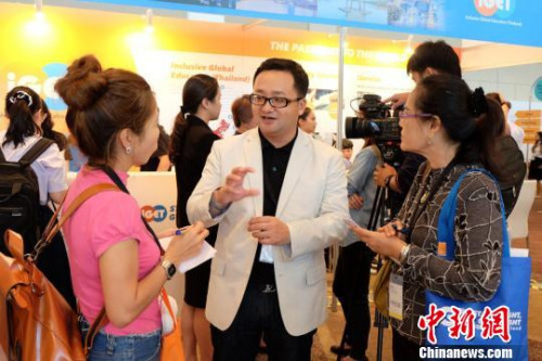 展臺工作人員認(rèn)真解答學(xué)生及家長的問題?！≮w婧楠 攝