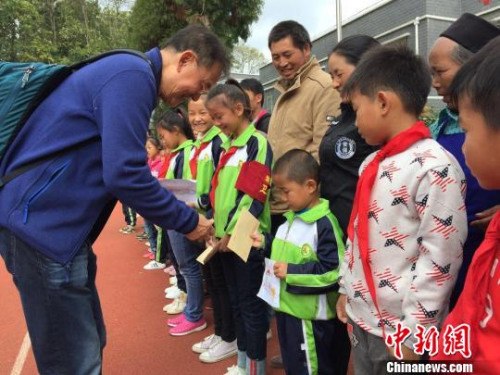 葉其超為受資助學(xué)生發(fā)放助學(xué)金。葉其超供圖。