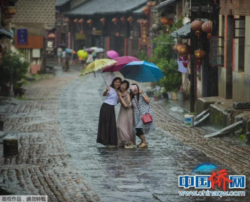 “相機(jī)攝”湖南永州市零陵老街，三位美女在雨中的老街玩自拍。
