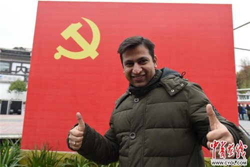 巴科在中國共產(chǎn)黨黨旗下豎起大拇指。吳蔚/攝